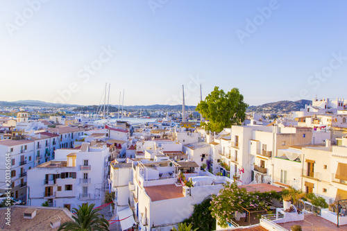 Aerial view from medieval fortress on old town, streets and roofs of houses and port of Ibiza Town, Balearic Islands, Spain