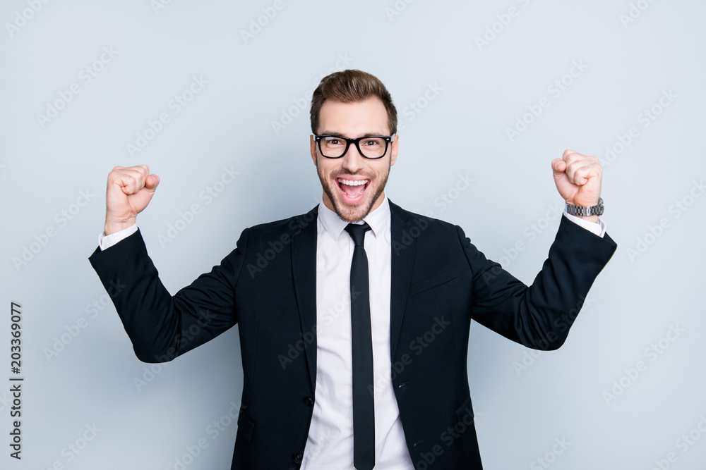 Whoo! We won the tender! Portrait of handsome emotional cheerful excited joyful fun wearing black classic suit man, isolated on gray background Whoo! We won the tender! Portrait of handsome emotional cheerful excited joyful fun wearing black classic suit man, isolated on gray background