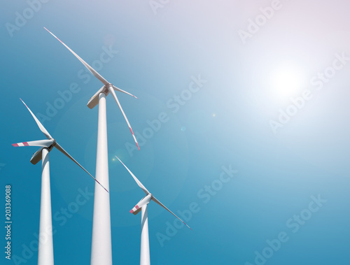 Three wind turbines on blue sky background, copy space © Natalia Gorsha