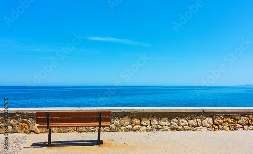 Lonely bench near blue sea