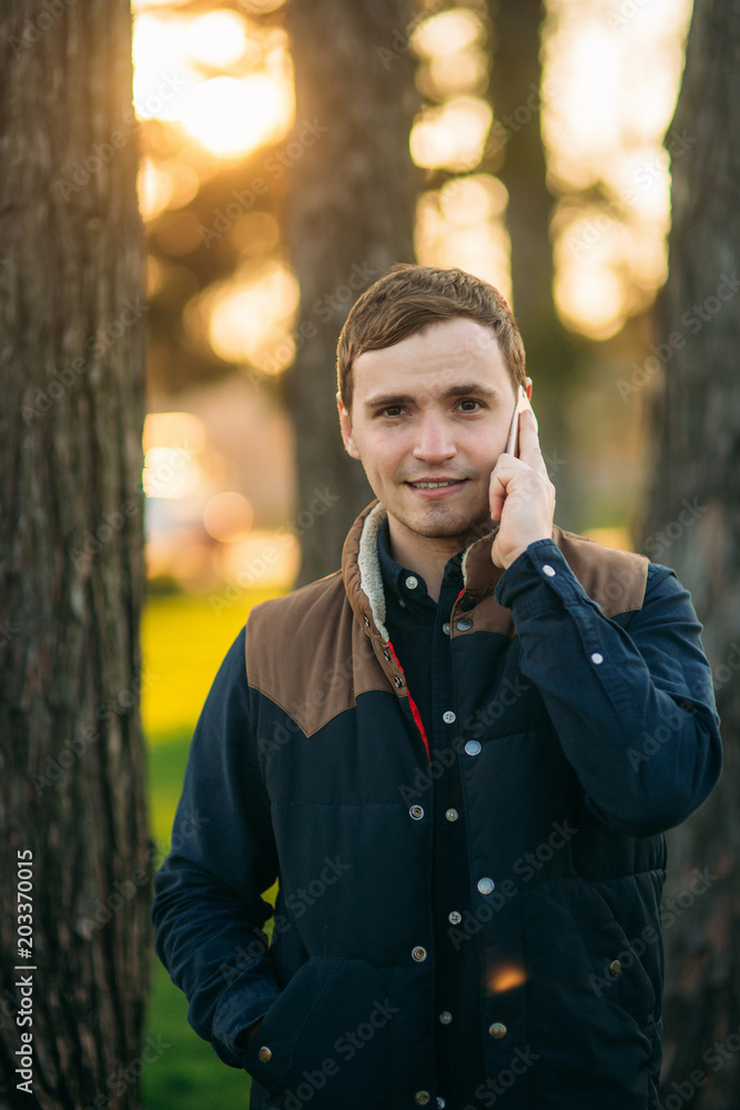 A young man speaks on his mobile phone. Business