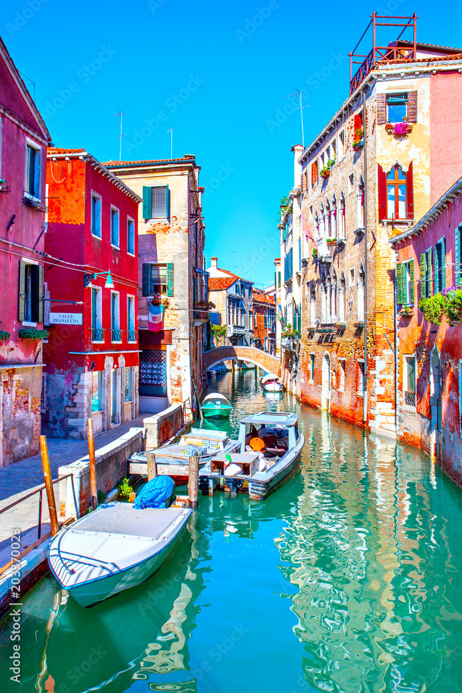 Side canal with moored motorboats in Venice