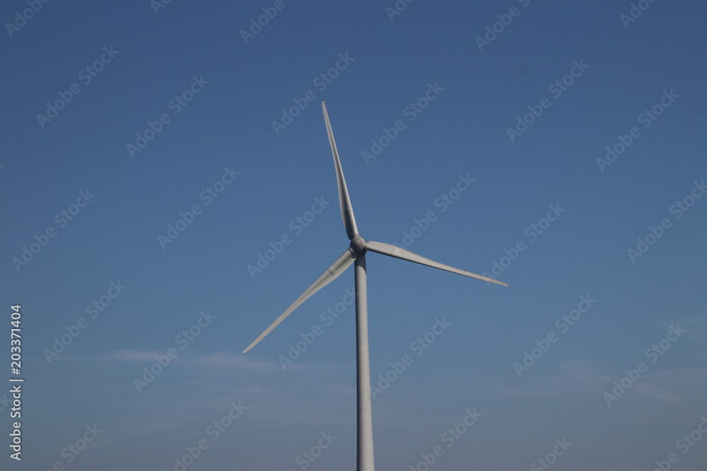 Fototapeta premium Windturbine in close-up with blue sky as background in the Netherlands.