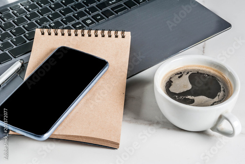 Workplace, white desk table with laptop, smartphone, coffee cup and notepad, Copy space