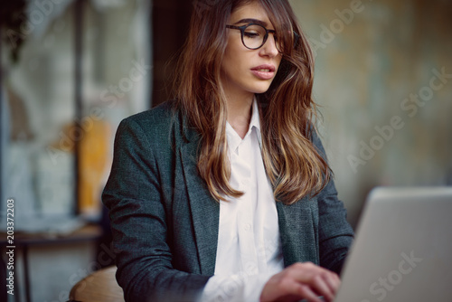 Free Download Young modern woman sitting in cafe and using laptop. - GFXLoad