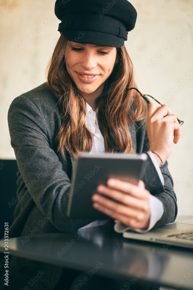 Young modern woman sitting in cafe and using tablet. Young modern woman sitting in cafe and using tablet.
