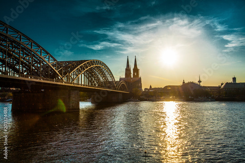 Cologne Cathedral and Hohenzollern Bridge at sunset, nighttime. Photo for postcard