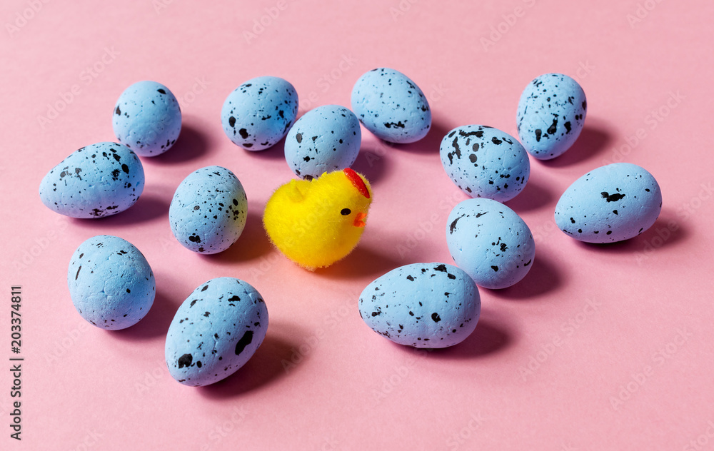 toy chicken and blue quail eggs on a pink background toy chicken and blue quail eggs on a pink background