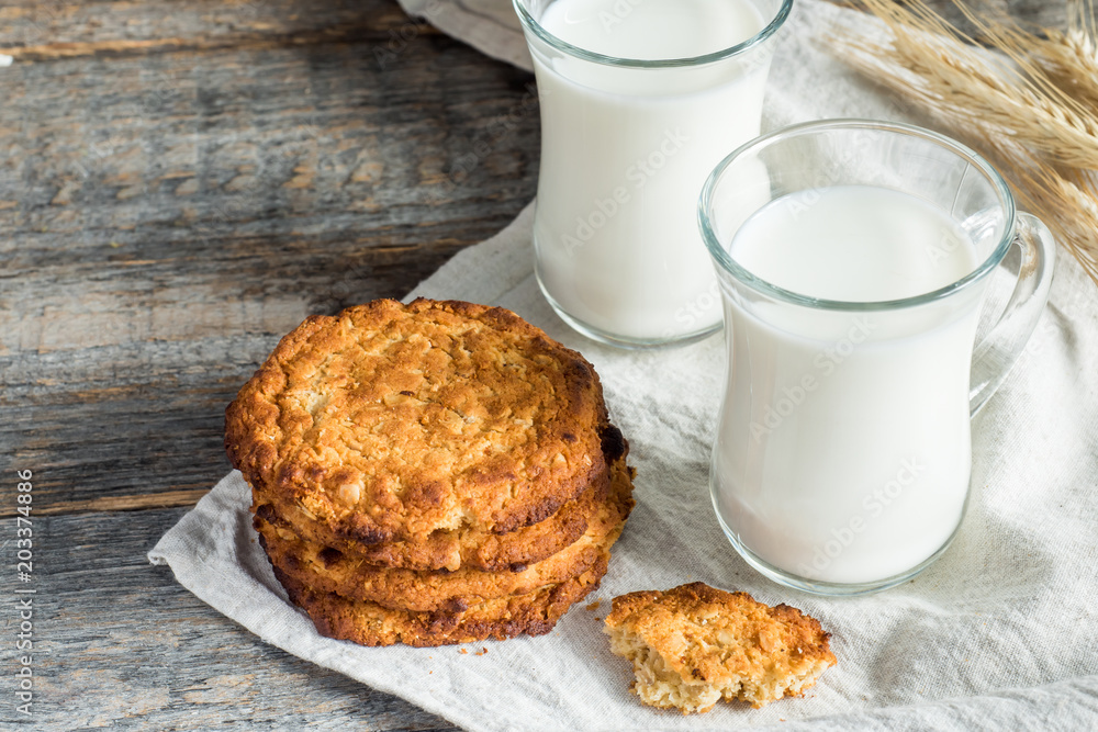 Fresh healthy milk and oatmeal cookies with cereals on wooden rustic background Fresh healthy milk and oatmeal cookies with cereals on wooden rustic background