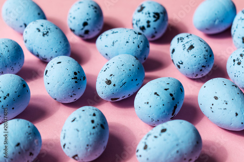 blue quail eggs on a pink background. closeup