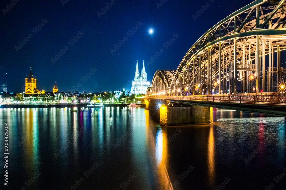 Cologne Cathedral and Hohenzollern Bridge at sunset, nighttime. Photo for postcard
