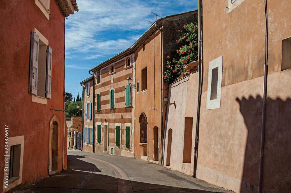 View of traditional colorful houses in ocher and street in the city center of the village of Roussillon. Located in the Vaucluse department, Provence region, southeastern France View of traditional colorful houses in ocher and street in the city center of the village of Roussillon. Located in the Vaucluse department, Provence region, southeastern France