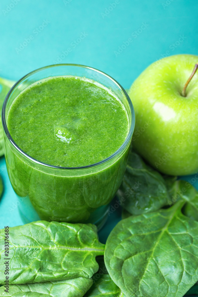Glass with Green Fresh Smoothie from Leafy Greens Vegetables Fruits Bananas Kiwi Cucumber. Scattered Spinach Leaves Apple on Turquoise Background. Healthy Lifestyle Detox Vitamins. Copy Space Glass with Green Fresh Smoothie from Leafy Greens Vegetables Fruits Bananas Kiwi Cucumber. Scattered Spinach Leaves Apple on Turquoise Background. Healthy Lifestyle Detox Vitamins. Copy Space
