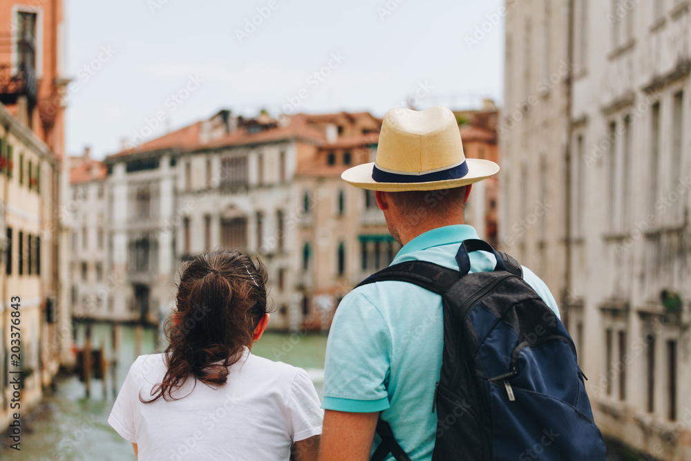 Back view of a Couple standing on the bridge over the canal at the Venice - Italy Back view of a Couple standing on the bridge over the canal at the Venice - Italy