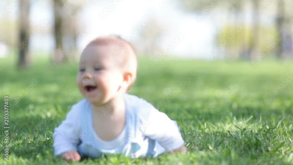 Cute toddler baby boy, playing in cherry blossom garden. Child with spring flowers in fruit orchard, cherry flower garden Cute toddler baby boy, playing in cherry blossom garden. Child with spring flowers in fruit orchard, cherry flower garden