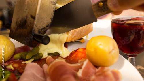 Photography raclette coulant sur assiette garnie