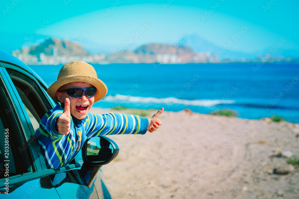 happy little boy enjoy travel by car at beach