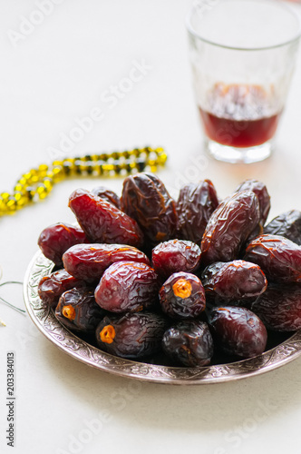 Medjoul - dried dates or kurma in a vintage plate and tea. photo