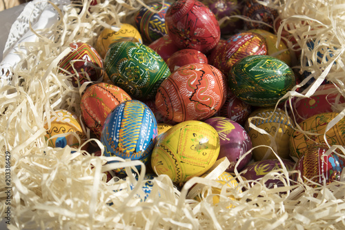 Fototapeta Naklejka Na Ścianę i Meble -  Colorful Easter wooden eggs in wooden chips shop for sale