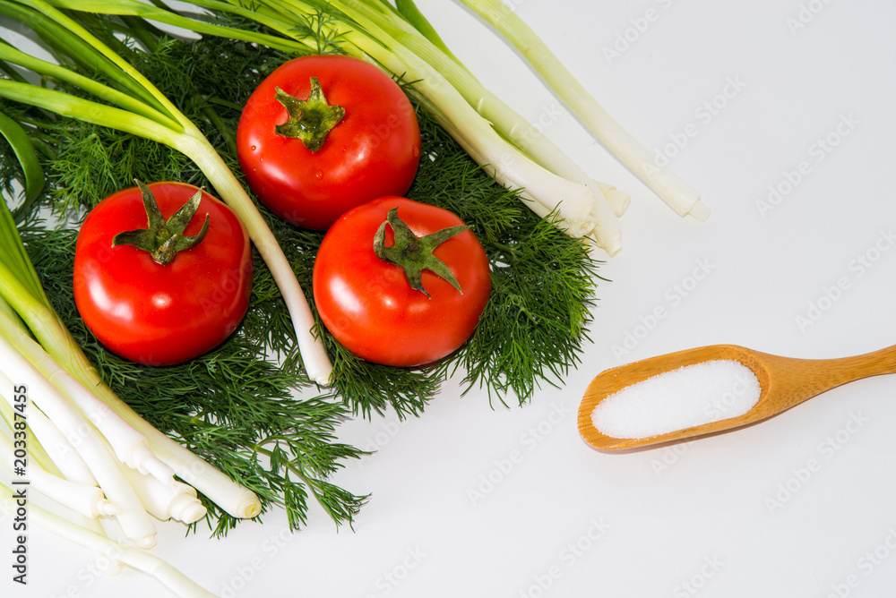 Green onions, tomatoes, dill and sal lying on a white background Green onions, tomatoes, dill and sal lying on a white background