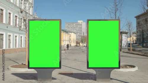 Two street billboard stands with green screen on time lapse pavemen. Seamless loop. photo