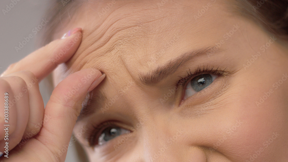 closeup portrait of middle age woman showing her skin closeup showing wrinkles in her forehead closeup portrait of middle age woman showing her skin closeup showing wrinkles in her forehead
