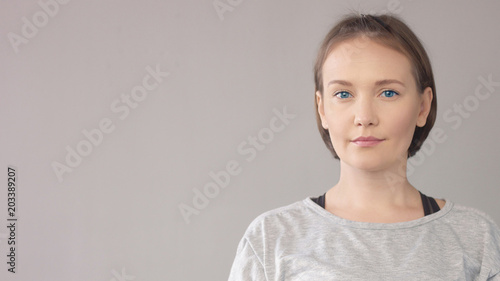 Closep portrait of midage caucasian woman on grey watching at camera