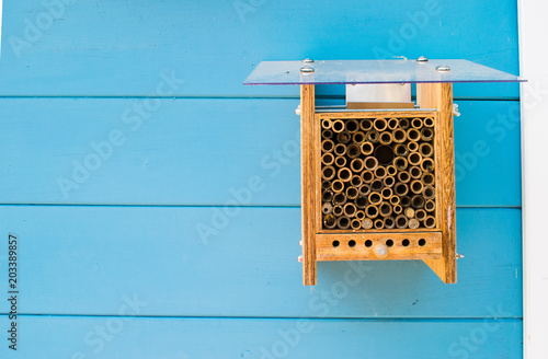 a little wooden beehive on a blue wall