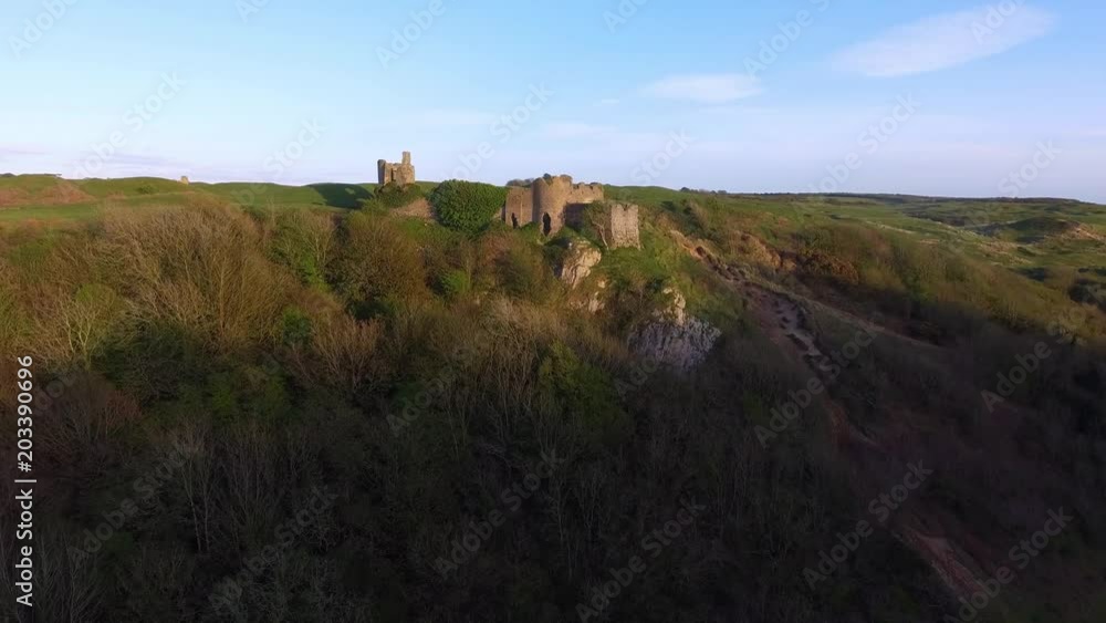 The ruins of Pennard castle on the Gower peninsula in Swansea, South Wales, UK, overlooking Three Cliffs Bay with Pennard Golf Club in the background. The ruins of Pennard castle on the Gower peninsula in Swansea, South Wales, UK, overlooking Three Cliffs Bay with Pennard Golf Club in the background.