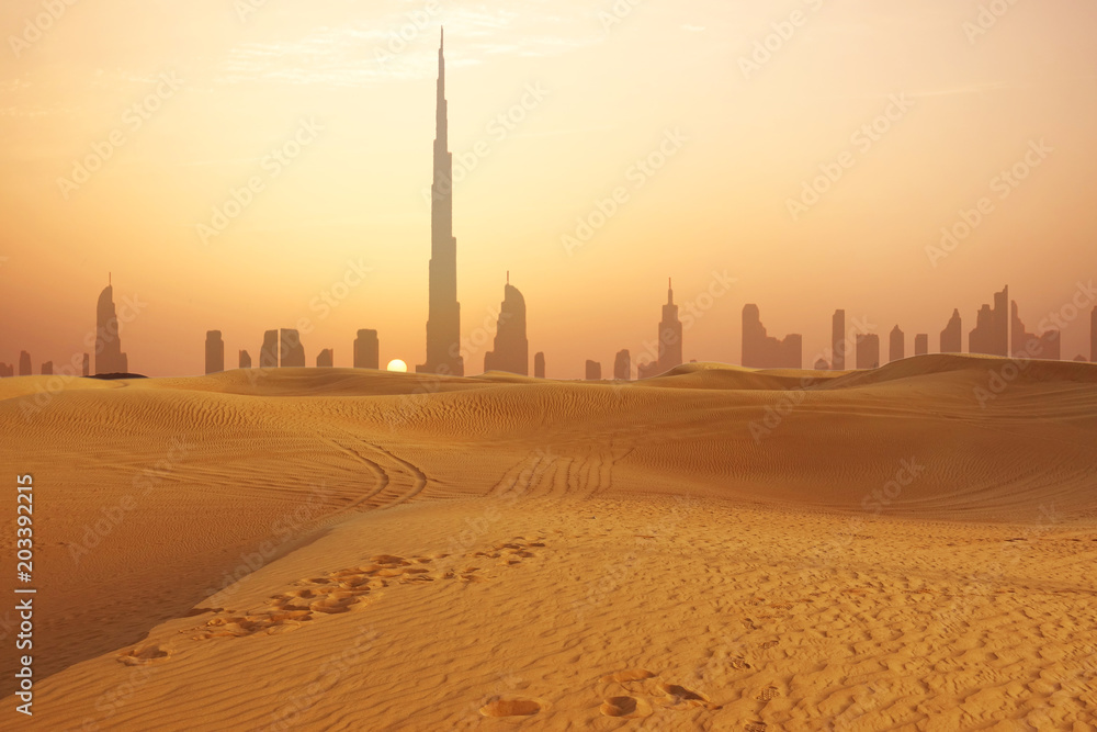 Naklejka premium Dubaj panoramę miasta o zachodzie słońca widziana z pustyni