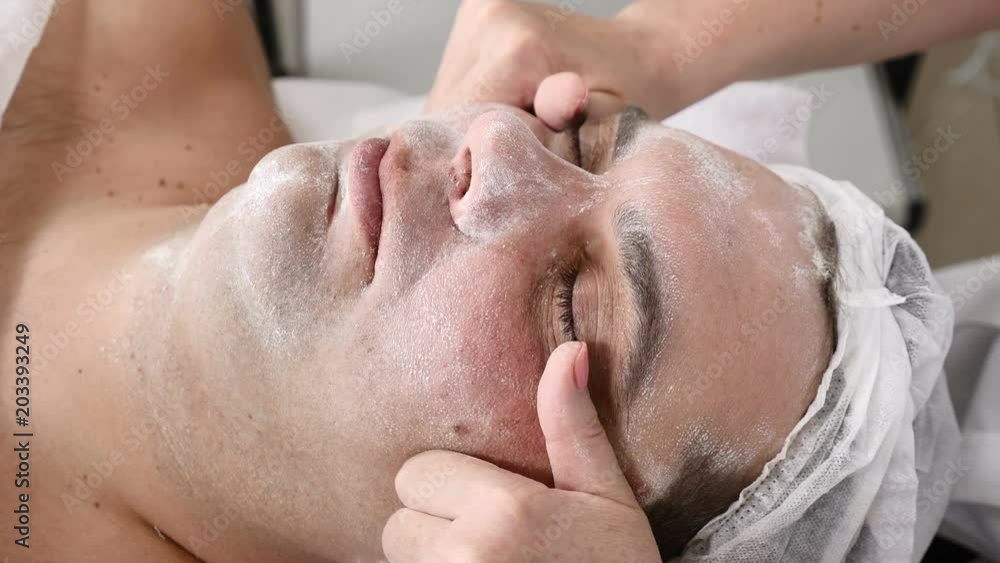 Man in beauty clinic. Male client gets facial cosmetology procedure in beauty salon. Face lymphatic massage Man in beauty clinic. Male client gets facial cosmetology procedure in beauty salon. Face lymphatic massage
