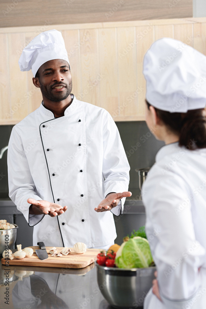 Multiracial chefs team discussing recipe and cooking on kitchen Multiracial chefs team discussing recipe and cooking on kitchen