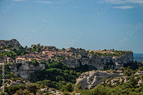 Panoramic view of the village and ruins of the Baux-de-Provence Castle on top of cliff and sunny blue sky. Bouches-du-Rhone department, Provence-Alpes-Côte d'Azur region, southeastern France