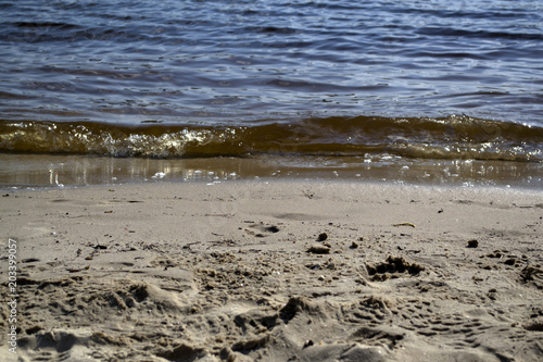 Wet sand and soft waves on a beach. © Natali Vinokurova