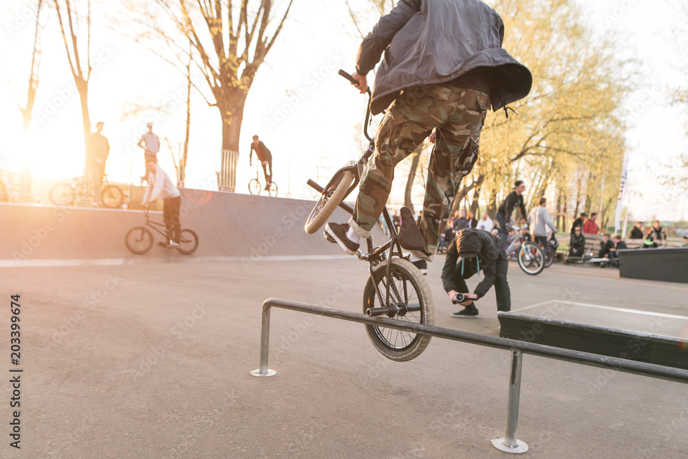 Foto Stock Crazy BMX rider performs tricks in the skate park on the  background of the sunset. Jump on the bike. BMX Riders Tournament. BMX  concept | Adobe Stock