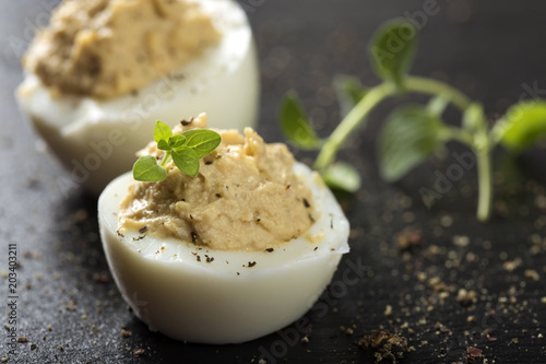 Close up of stuffed eggs with herbs on a dark slate