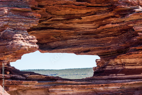 Scenic Panorama from lookout through nature window over gorge in Kalbarri National Park, in outback Western Australia, Murchison River, rough rugged rock formation, summer sunny blue sky, copy space. photo