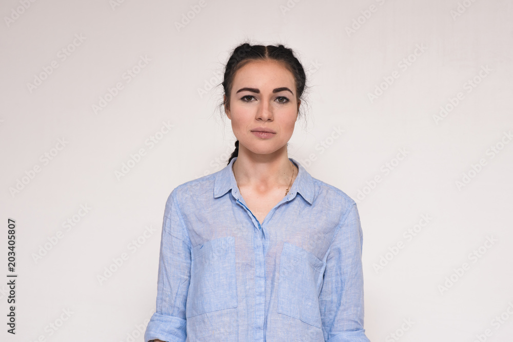 Portrait of a beautiful serious brunette girl on a white background Portrait of a beautiful serious brunette girl on a white background