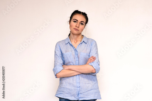 Portrait of a beautiful serious brunette girl on a white background