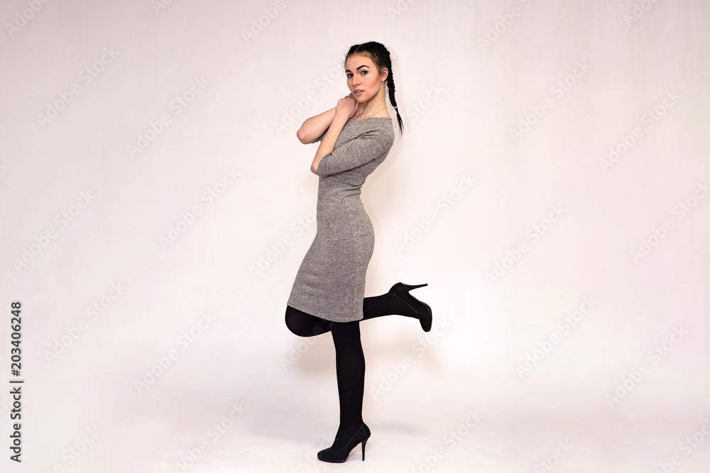 Portrait of a beautiful brunette girl on a gray background in different poses. Portrait of a beautiful brunette girl on a gray background in different poses.