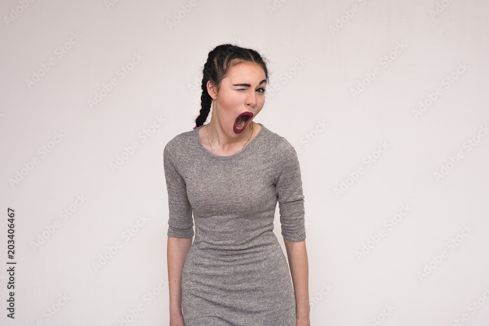 Portrait of a beautiful brunette girl on a gray background brightly showing emotions Portrait of a beautiful brunette girl on a gray background brightly showing emotions