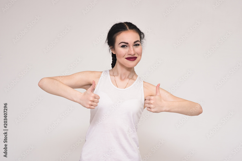 Portrait of happy beautiful brunette girl showing ok on grey background. Portrait of happy beautiful brunette girl showing ok on grey background.