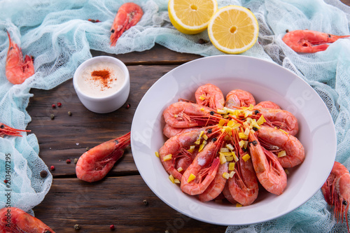 Shrimp sauce with boiled shrimps is served with a lemon and a dried peel