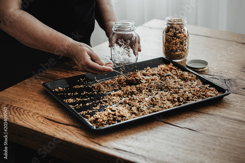 Valokuva Woman filling a mason jar with homemade granola