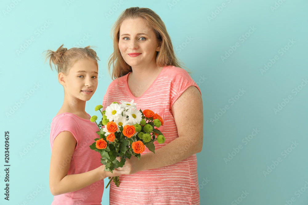 Portrait of happy mother and daughter with bouquet of flowers on color background Portrait of happy mother and daughter with bouquet of flowers on color background