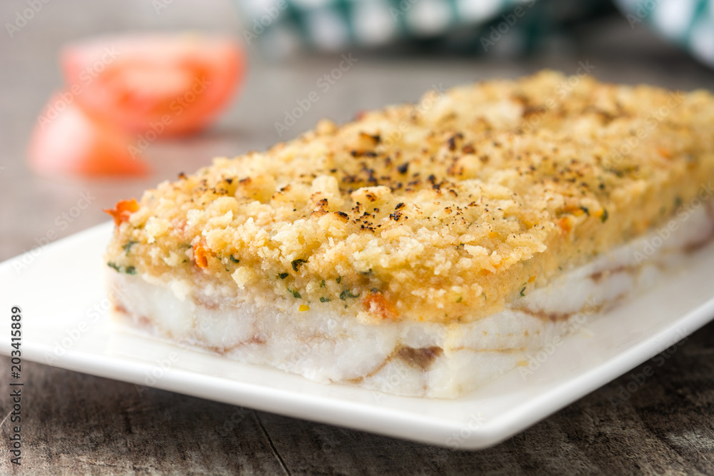 White fish casserole with cheese on wooden background.