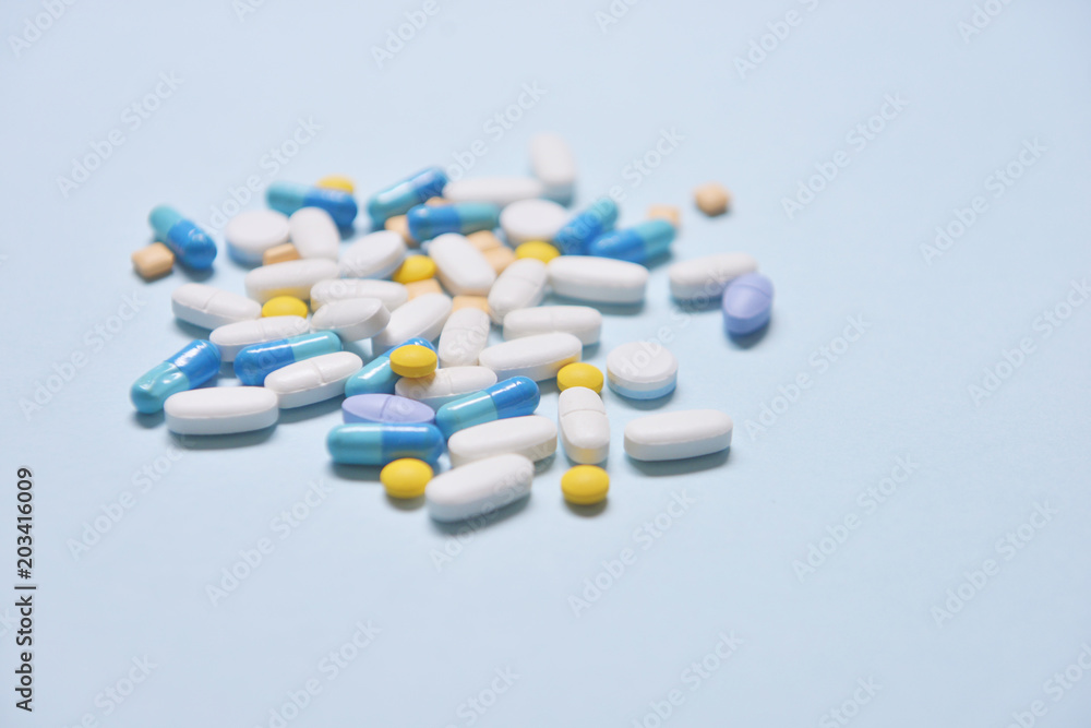 Healthcare and medical series - medicine pills, tablets and capsules on blue background