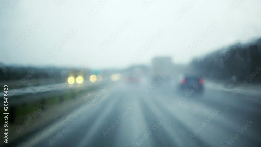 Rain drops splatters on windshield during rain storm, difficult driving conditions Rain drops splatters on windshield during rain storm, difficult driving conditions