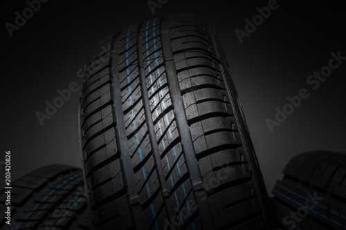 New and unused car tires against dark background