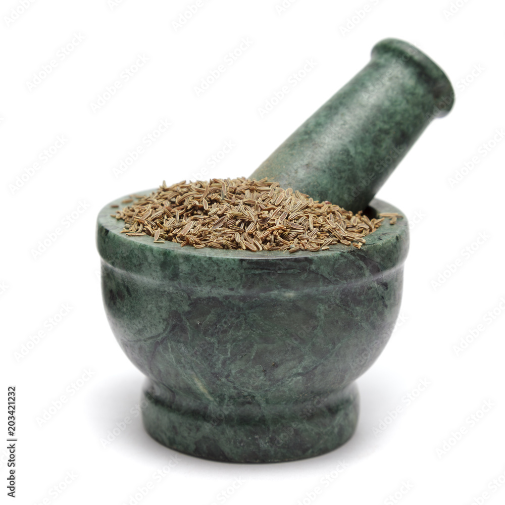 Organic Cumin seed (Cuminum cyminum) on marble pestle. Isolated on white background. Organic Cumin seed (Cuminum cyminum) on marble pestle. Isolated on white background.